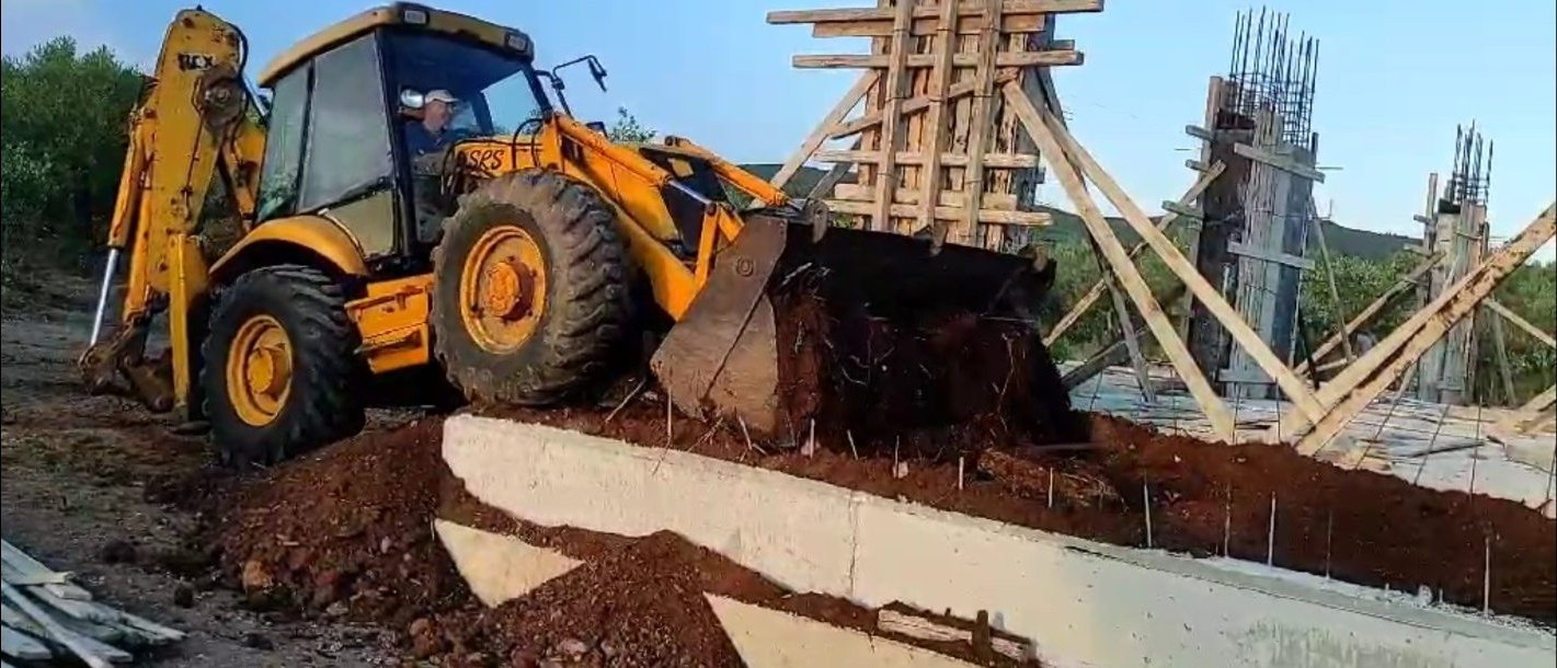JCB διαμορφώνει χώμα γύρω από θεμέλια με κολόνες